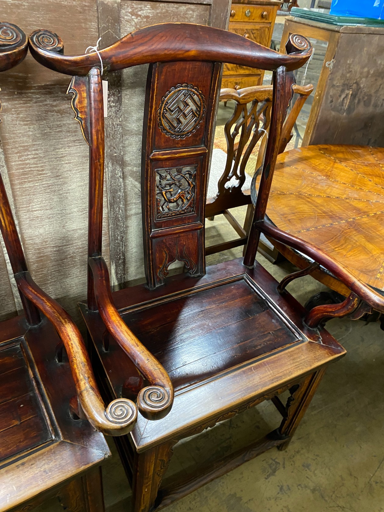 A pair of Chinese elm elbow chairs, width 63cm, depth 50cm, height 118cm